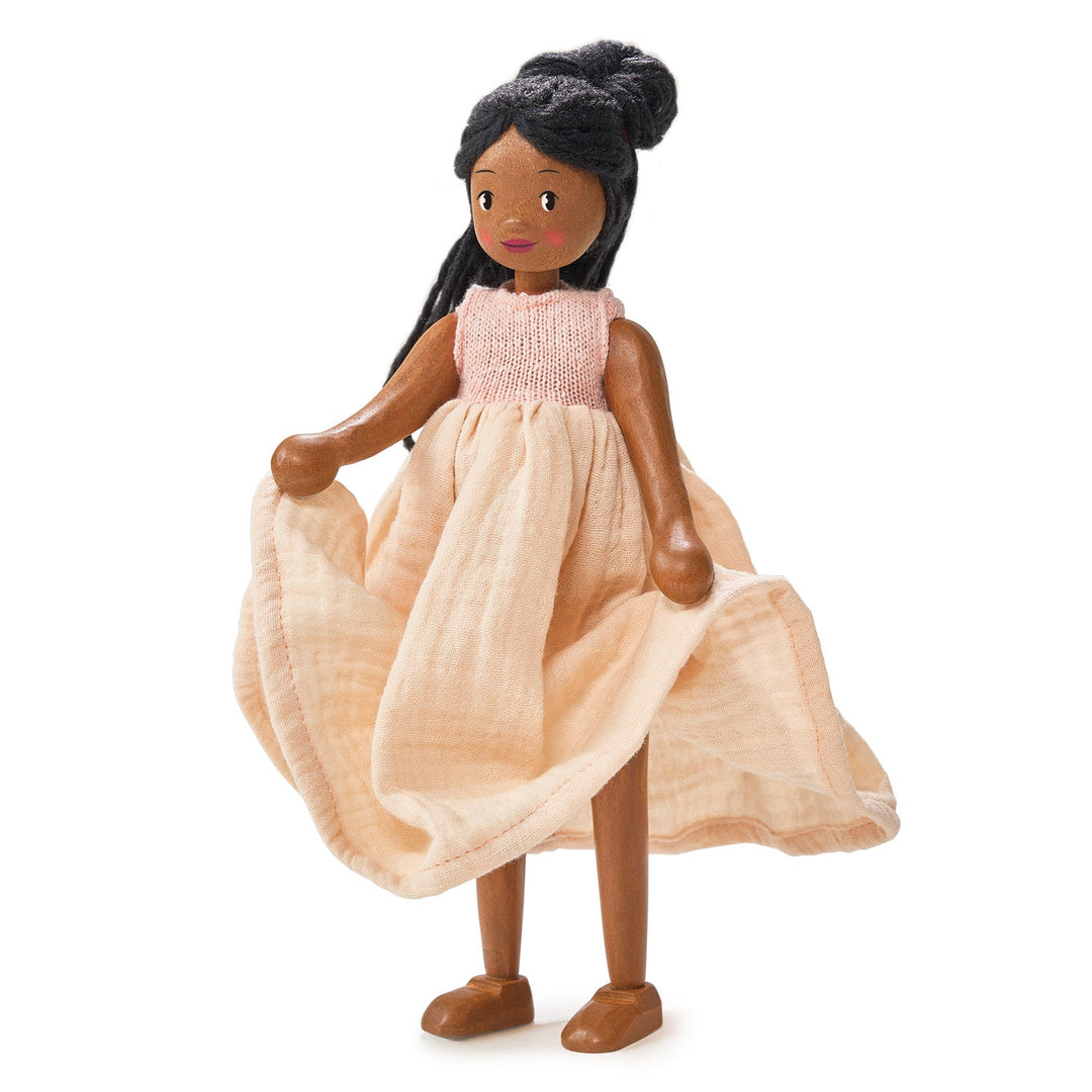 Doll with a pink top and beige dress on a white background