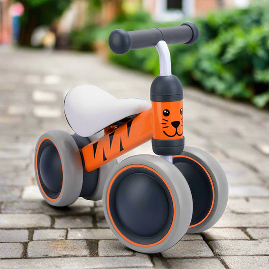 Children's balance bike with tiger design on a cobbled pavement background