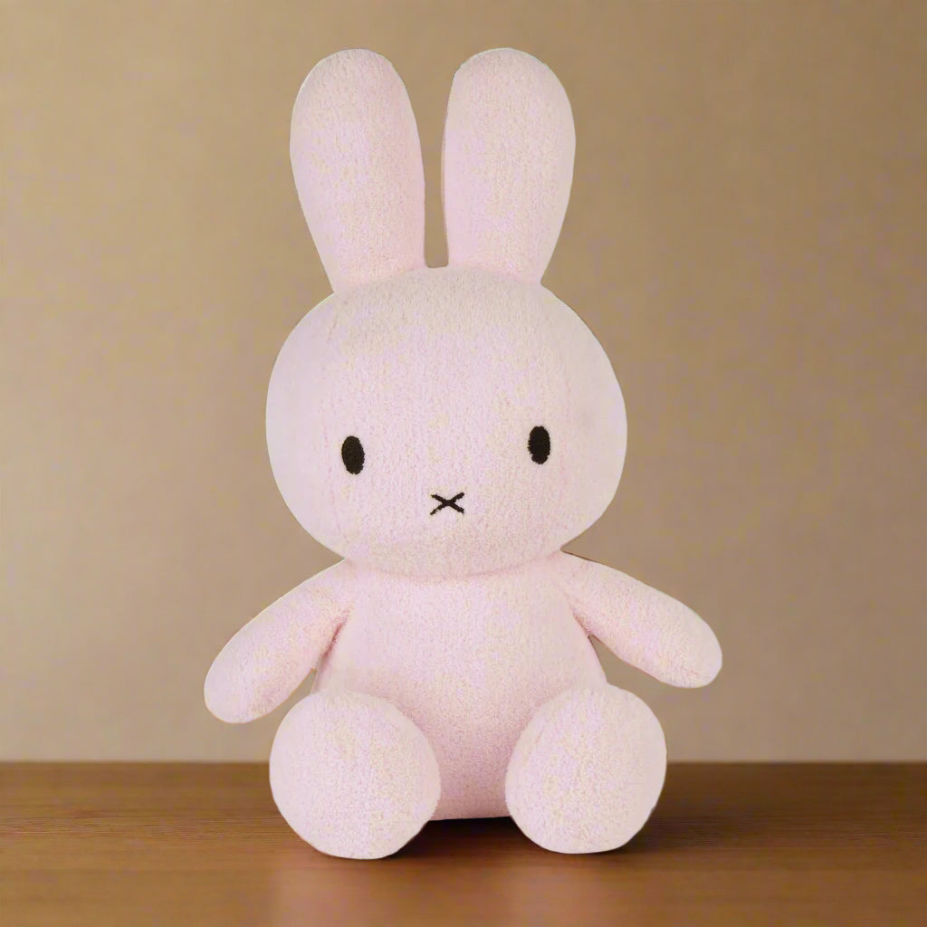 Large pale pink plush stuffed toy rabbit with iconic cross stitched mouth