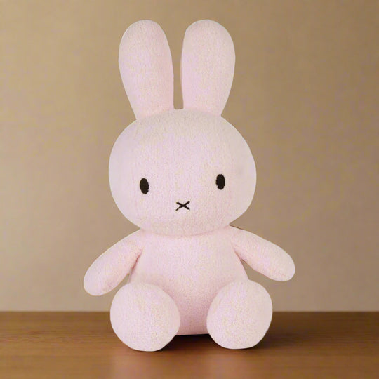 Large pale pink plush stuffed toy rabbit with iconic cross stitched mouth
