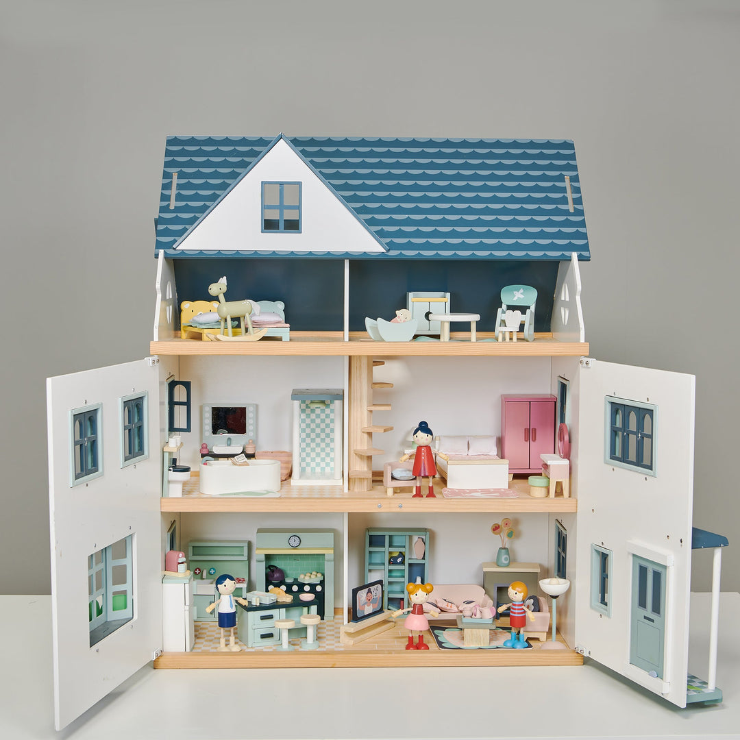 Wooden dollhouse with detailed interior and furniture on a grey background