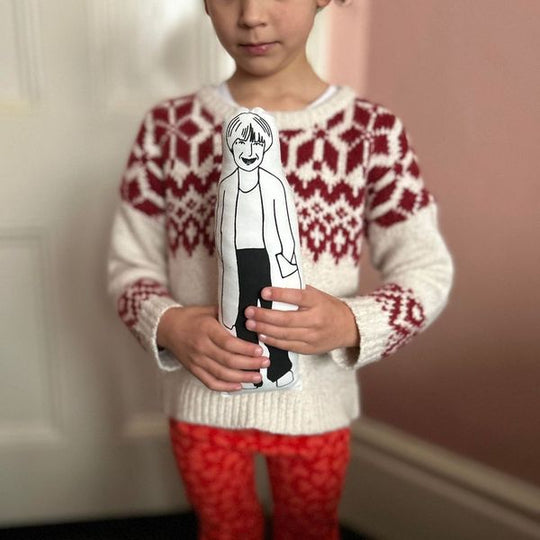 A child holding a screen printed black ansd white doll of Victoria Wood