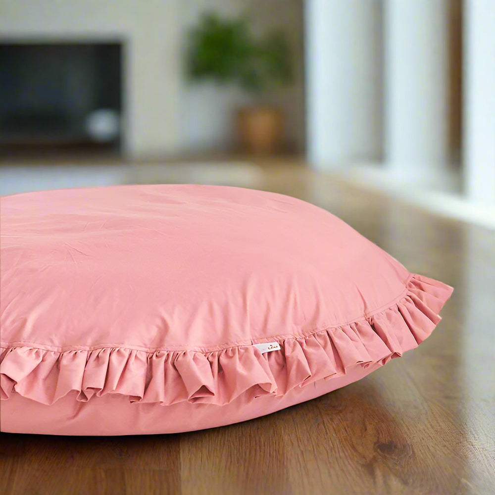 Pink pillow with ruffled edge on a light background
