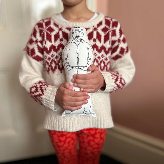 A child holding the screen printed doll cushion of Paul Hollywood