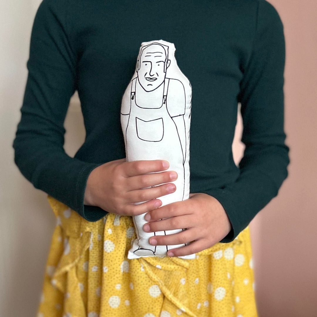 A child holding screen printed doll cushion of Keith Brymer Jones