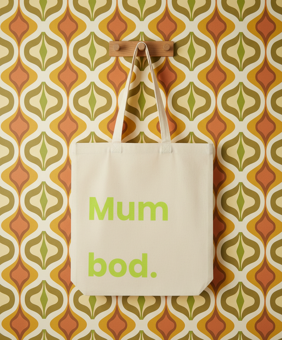 Beige tote bag with 'Mum bod.' text on a patterned wall background