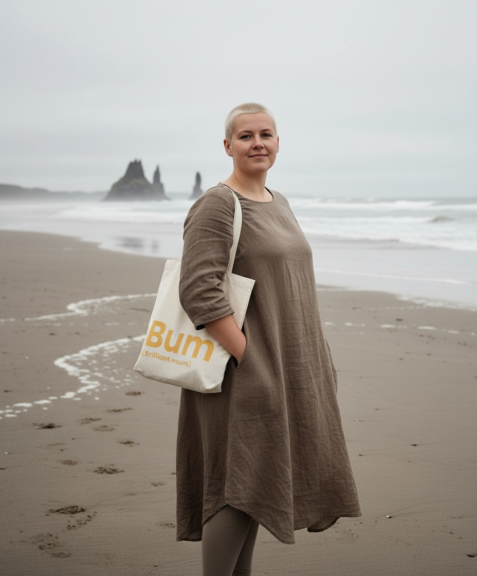 Woman holding a tote bag with 'Bum' printed on it on a beach.