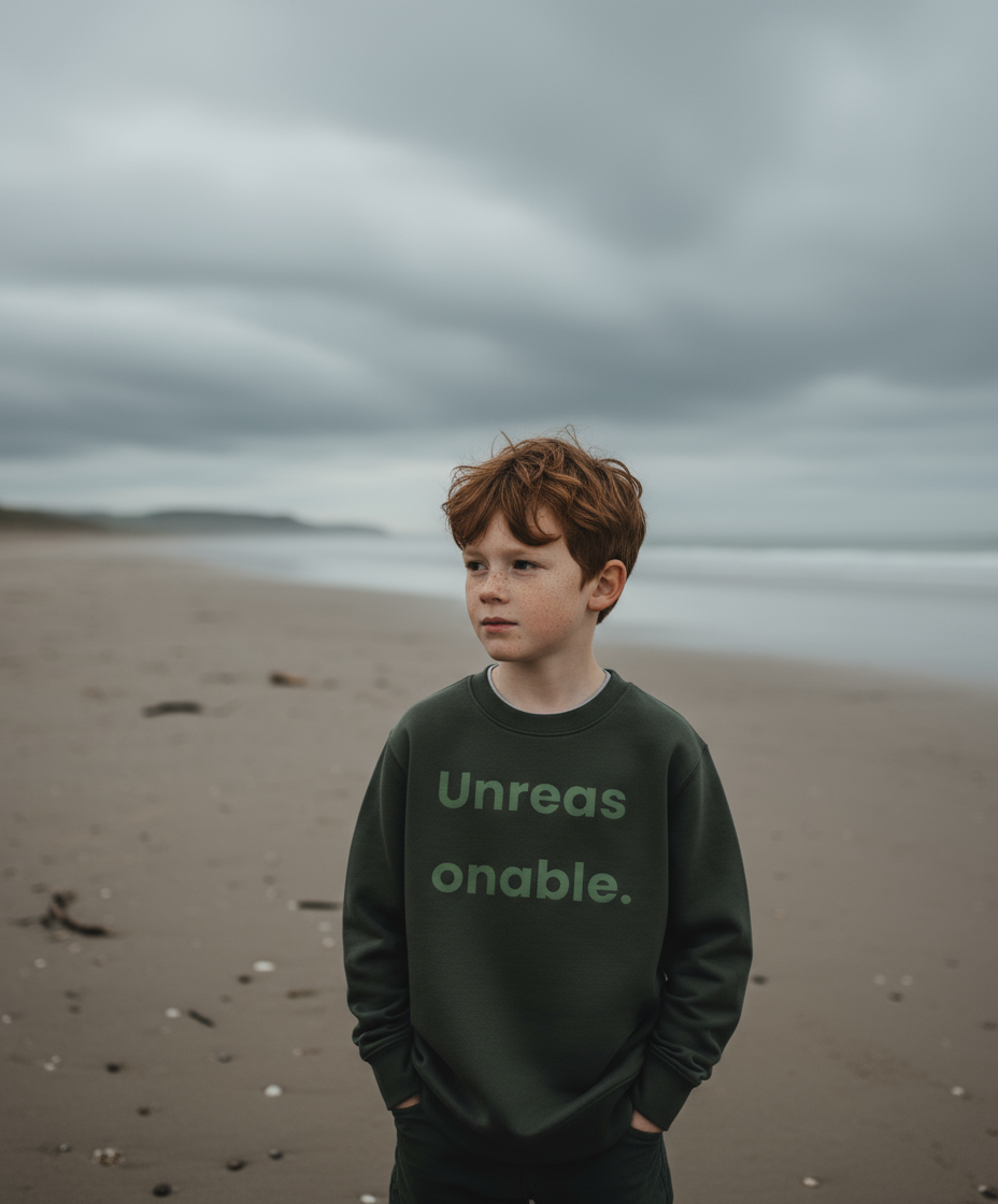 Child wearing a sweatshirt with text on a beach