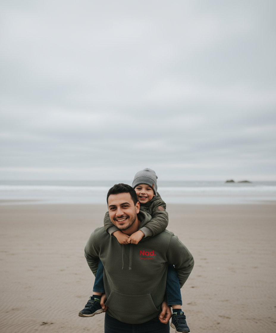 Man and child on a beach with a cloudy sky