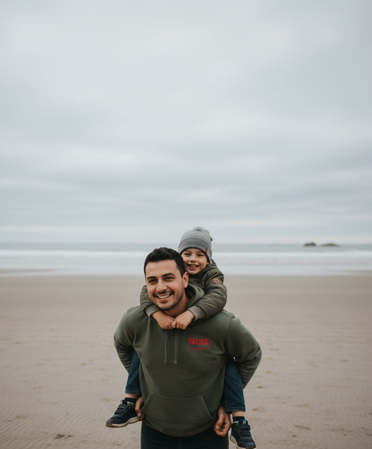 Man and child on a beach with a cloudy sky