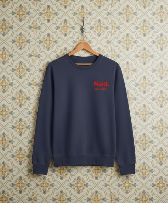 Navy blue sweatshirt with red text on a hanger against a patterned wall.