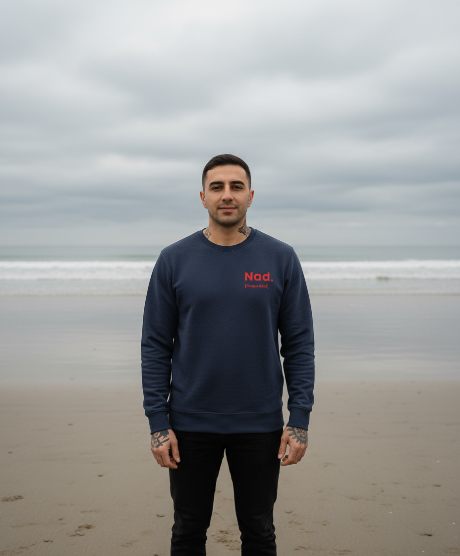 Man wearing a navy blue sweatshirt with red text on a beach