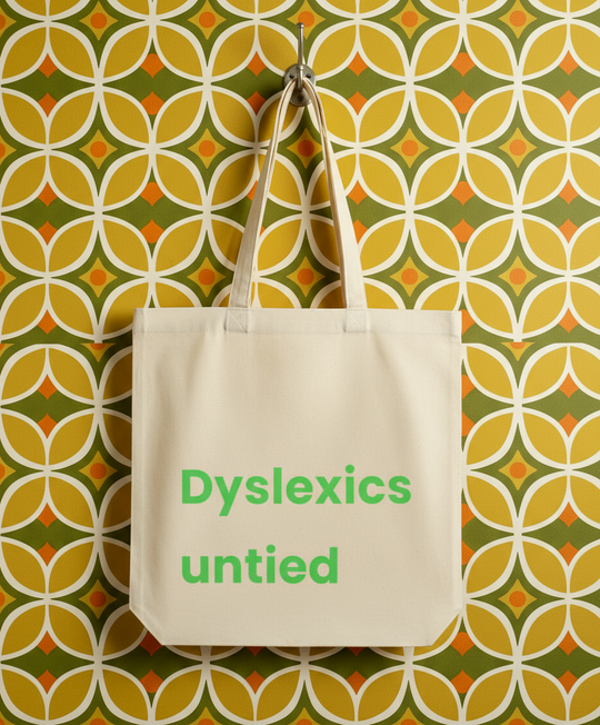 Tote bag with 'Dyslexics untied' text on a patterned wall background