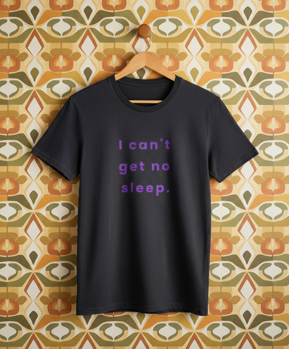 Navy t-shirt with 'I can't get no sleep.' text on a patterned wall background