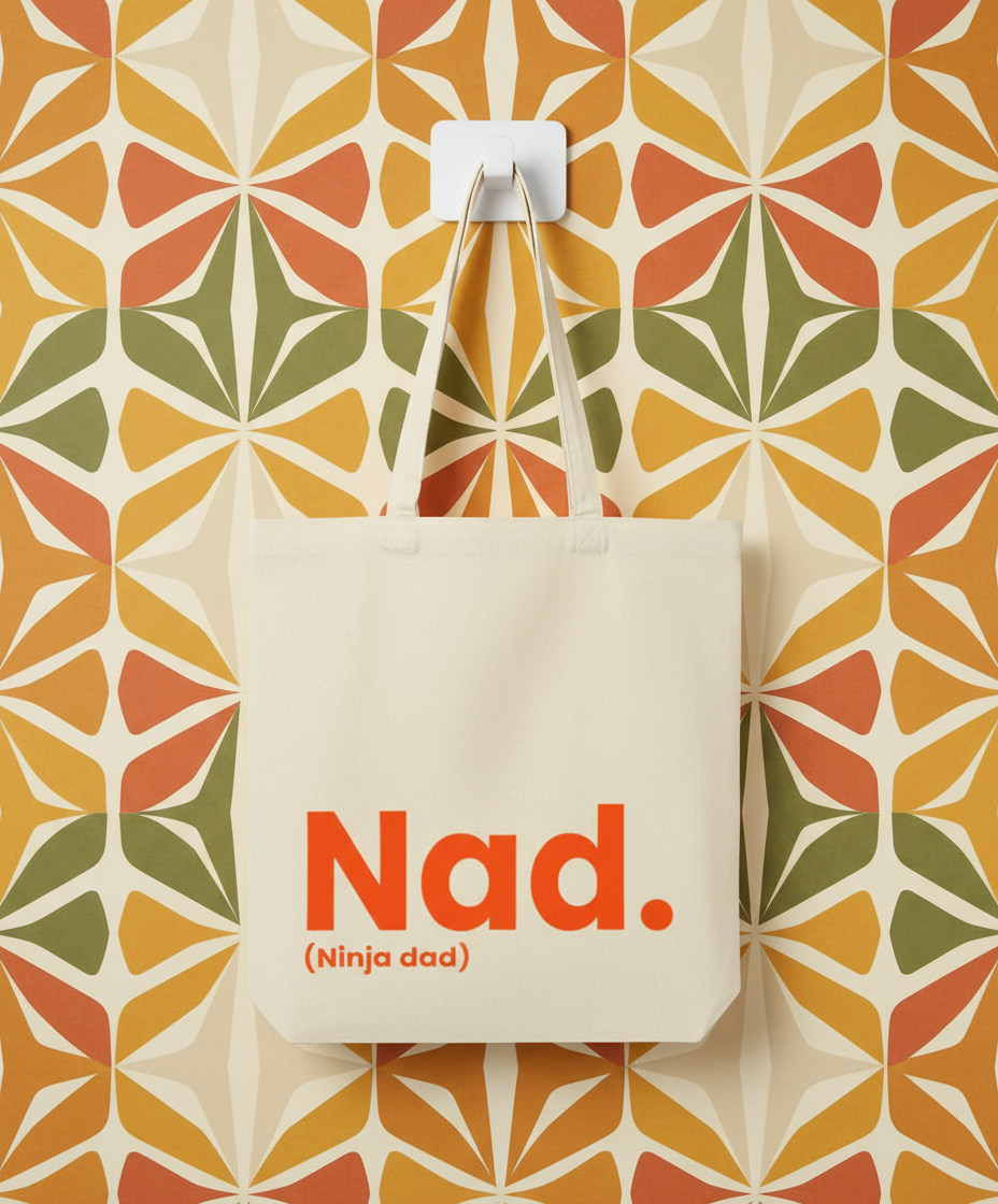 Tote bag with 'Nad. (Ninja dad)' text against a geometric patterned wall.