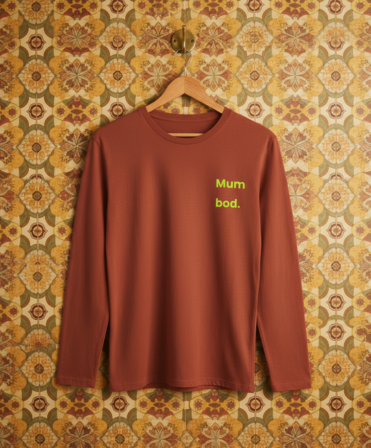 Brown long-sleeve shirt with 'Mum bod.' text on a floral wall background