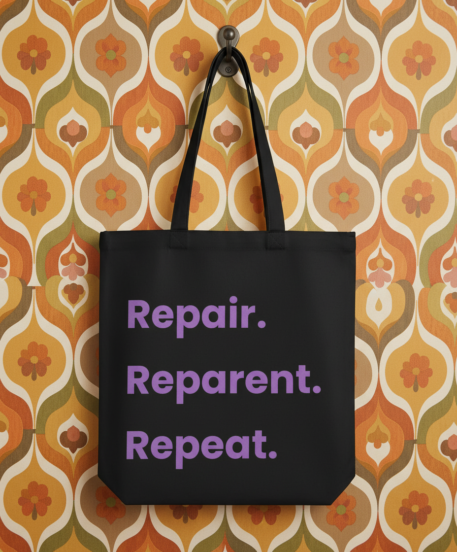 Black tote bag with purple text 'Repair. Reparent. Repeat.' on a patterned wall background