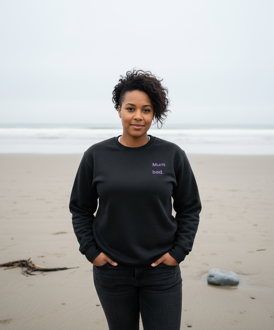 Woman stood on beach wearing black sweatshirt