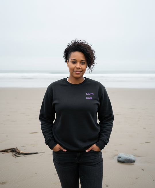 Woman stood on beach wearing black sweatshirt