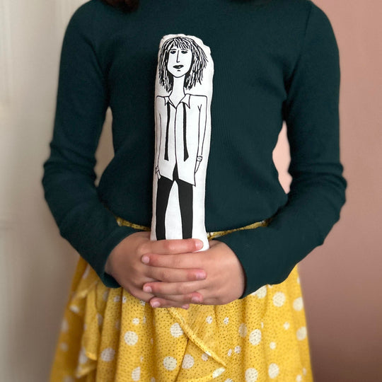 A child holding the screen printed doll cushion of Patti Smith