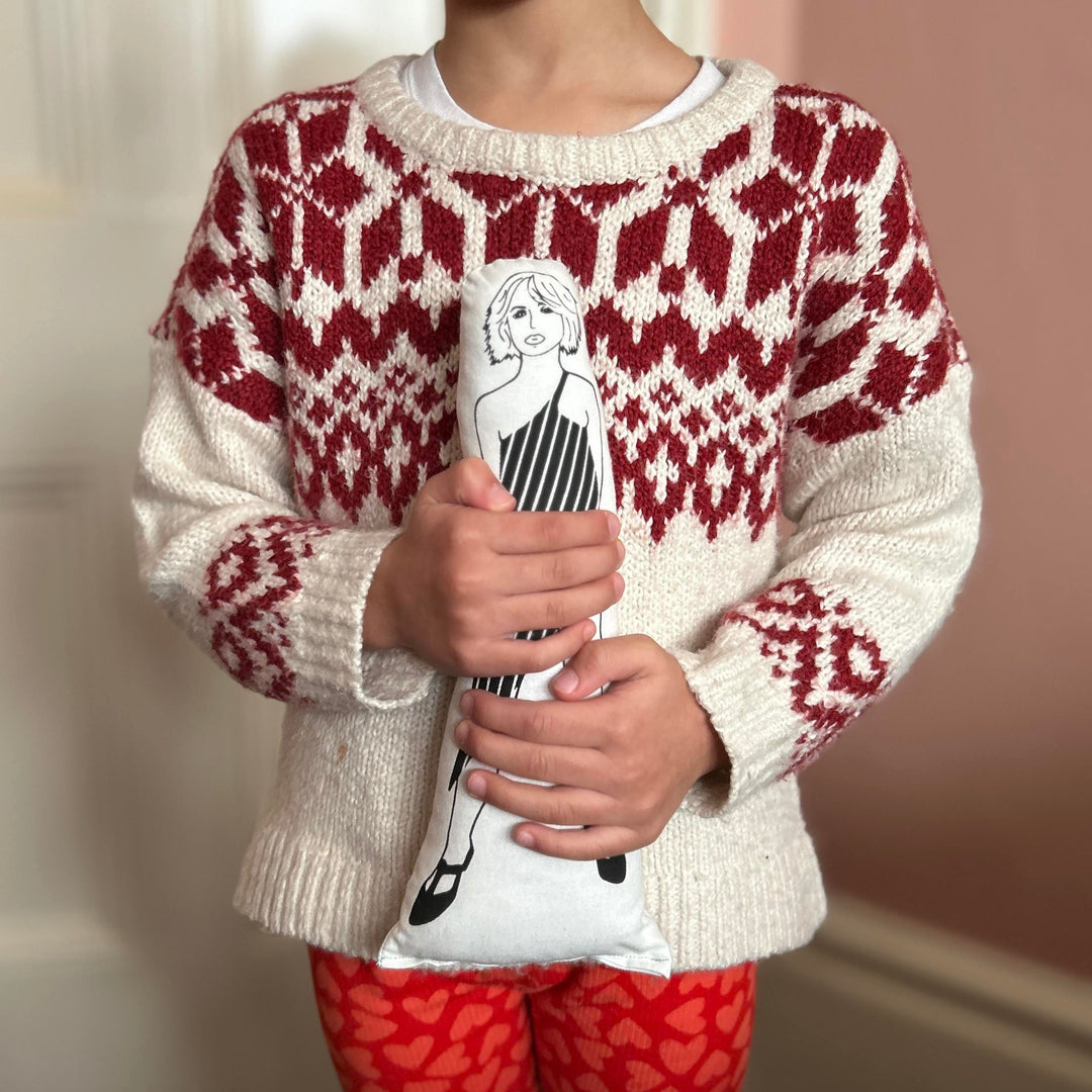 A child holding a screen printed doll cushion of Debbie Harry