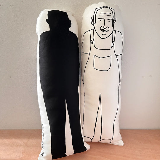 Two screen printed doll cushions of Keith Brymer Jones, one facing forwards and one facing backwards showing the sillouette outline on reverse