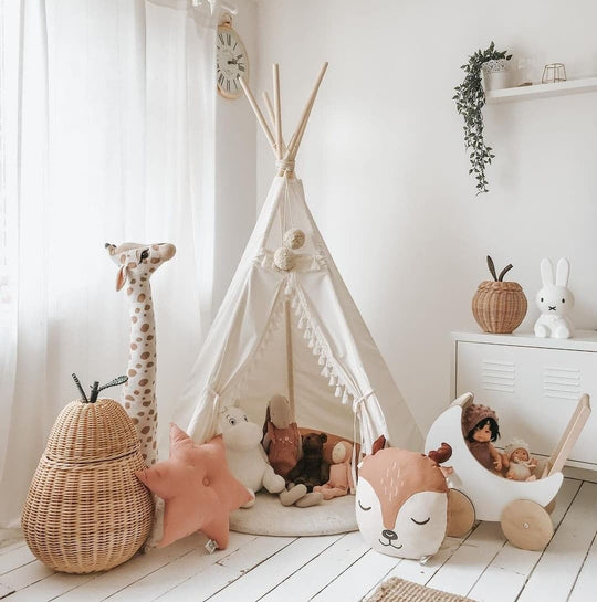 Children's playroom with a teepee, toys, and decorative items on a wooden floor.