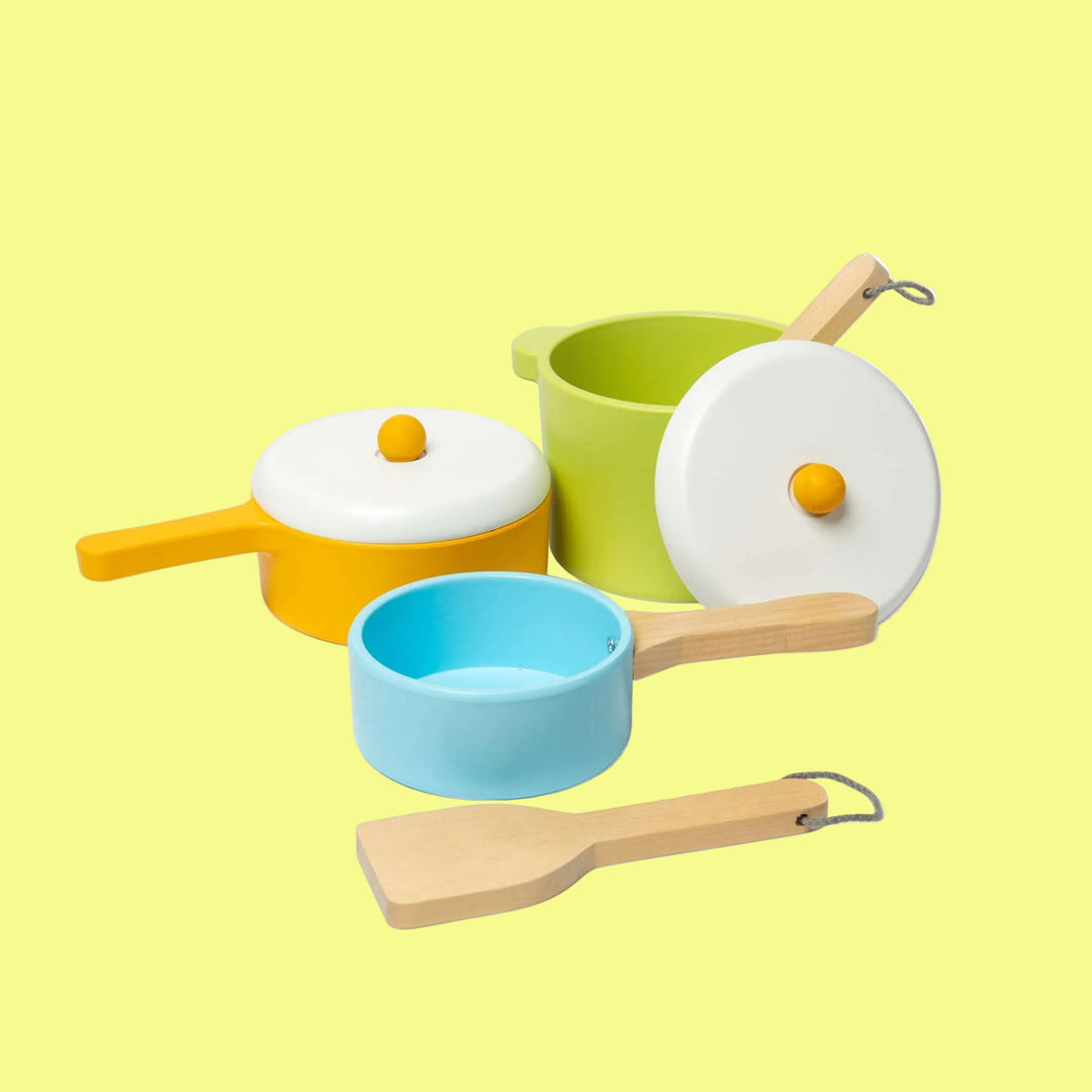 Colorful toy kitchen set with pots, pans, and utensils on a white background