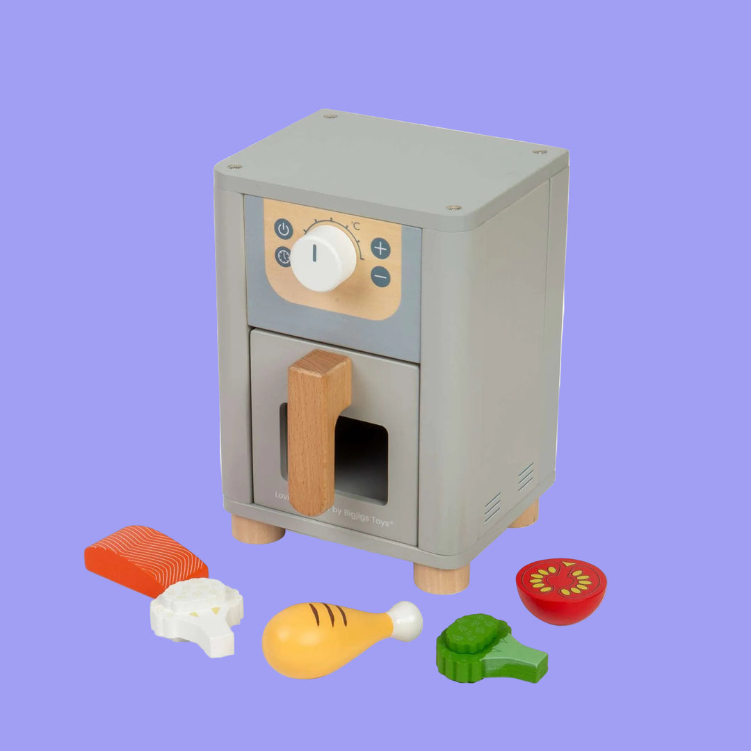 Toy oven with wooden door and various food items on a white background