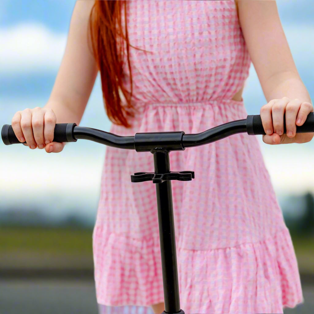 Close up of child's hands holding onto the black handlebars of the scooter