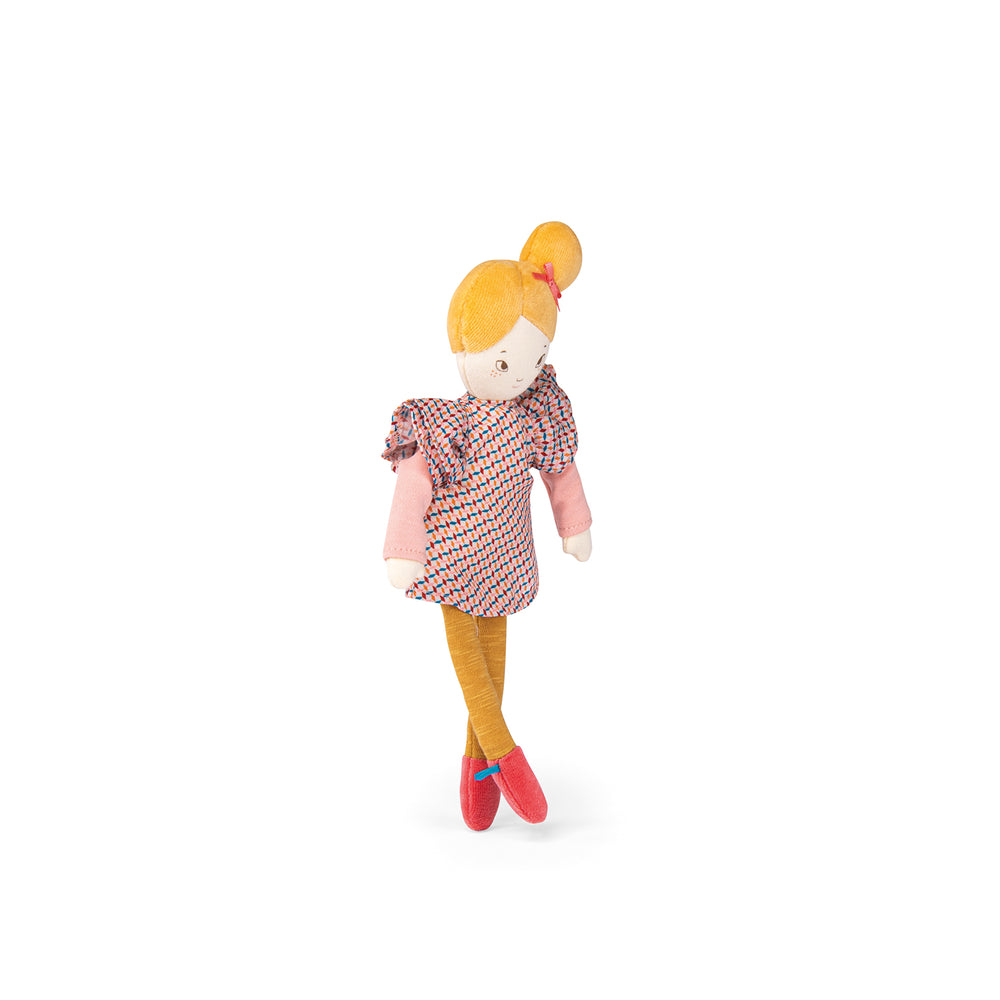 Toy doll turned to the side, with her legs crossed, wearing a purple patterned dress, yellow leggings/tights and pick shoes