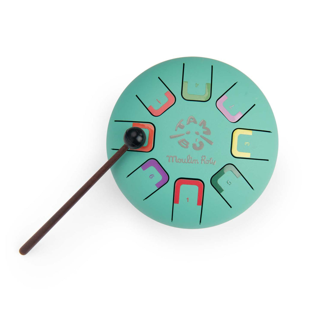 Teal coloured metal tongue drum instrument with colour-coded nots with a brown drumstick