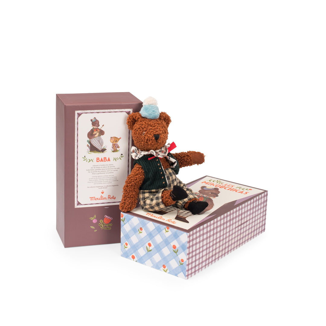 Teddy in outfit sat on decorative packaging box