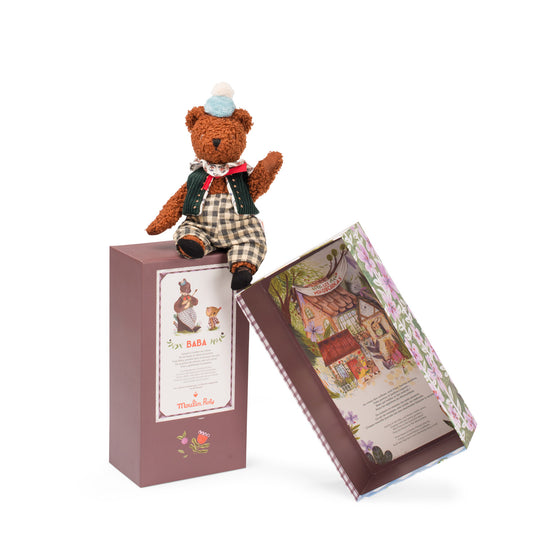 Teddy bear sitting on decorative packaging with arm raised