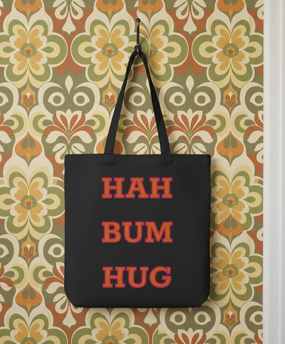 Black tote bag with 'HAH BUM HUG' text on a floral-patterned wall.
