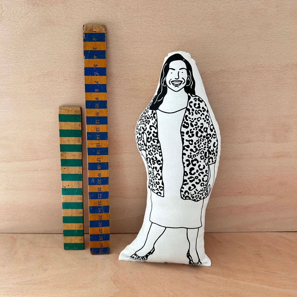 Screen printed doll cushion of Allison Hammond next to two wooden rulers