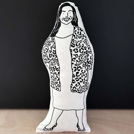 Screen printed doll cushion with white fabric and black illustration depicting TV presenter Allison Hammond wearing a dress and a leopard print cardigan with hoop earrings