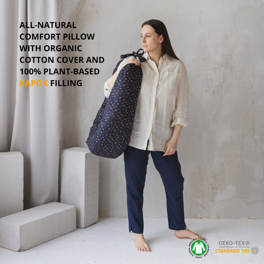 Woman holding a pillow with text about its natural materials in a minimalistic setting