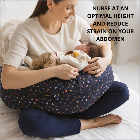 Woman holding a baby using a nursing pillow with text about optimal height and abdominal strain reduction.