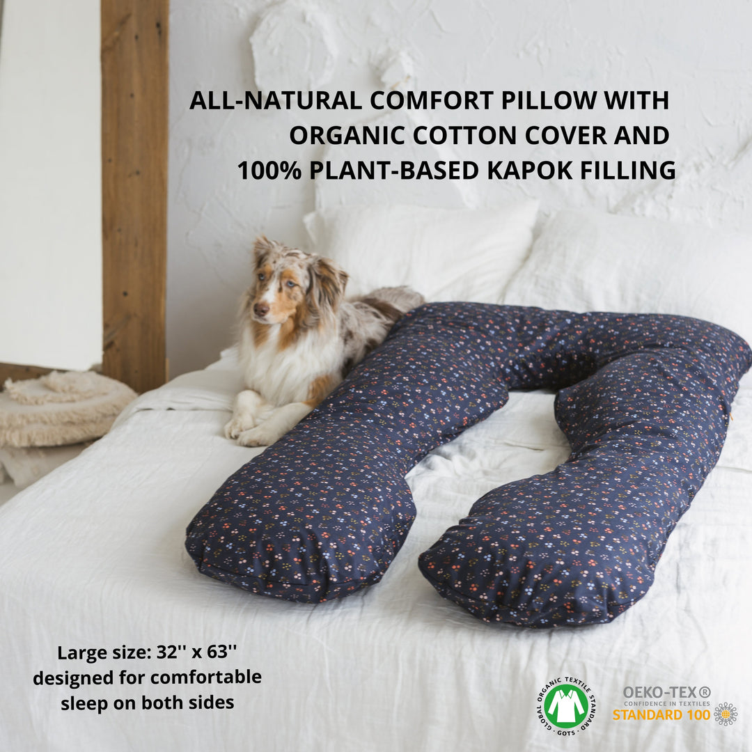 All-natural comfort pillow with organic cotton cover and plant-based kapok filling on a bed with a dog.