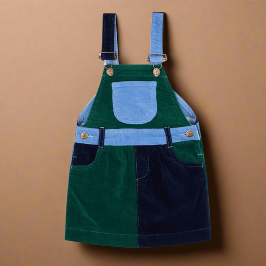Corduroy dress with blocks of different colours, pale blue, dark green and dark blue, with two side pockets and a central chest pocket, and brass buttons