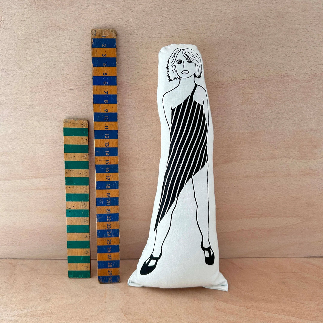 Screen printed doll cushion of Debbie Harry next to two wooden rulers and a wooden background