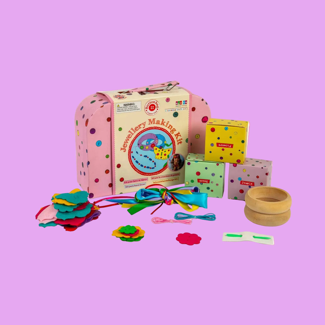 Jewelry making kit with colorful components and a pink polka dot box on a white background