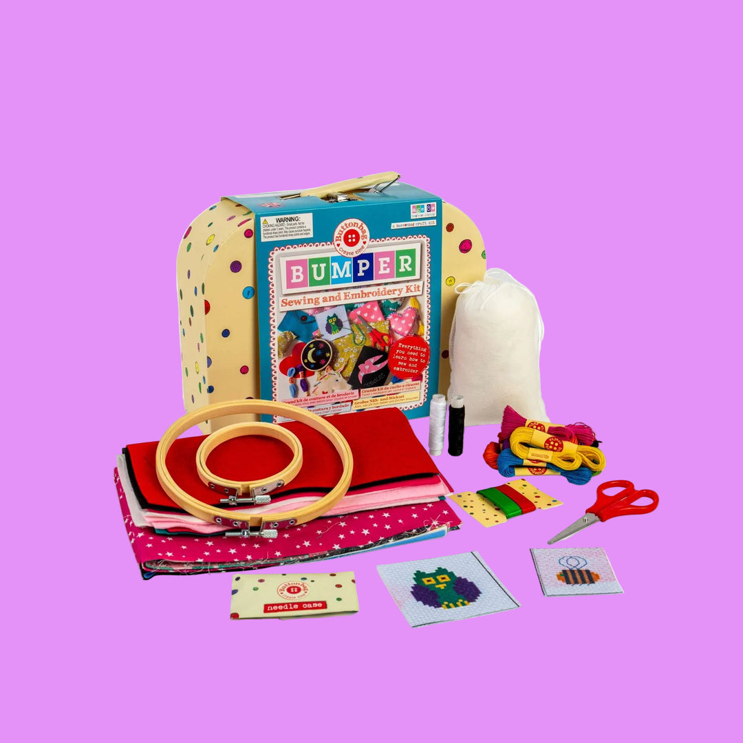 Sewing and embroidery kit with various tools and materials on a white background