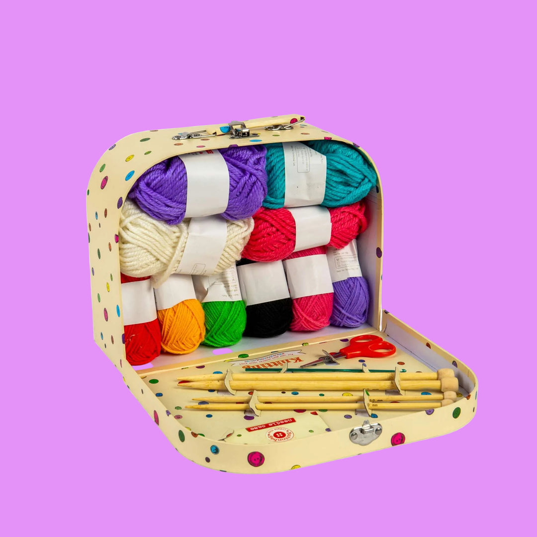 Colorful yarn set with knitting needles and scissors in a polka dot case on a white background