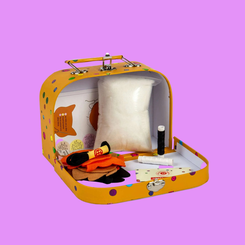 Yellow craft kit with various items including fabric, scissors, and thread on a white background