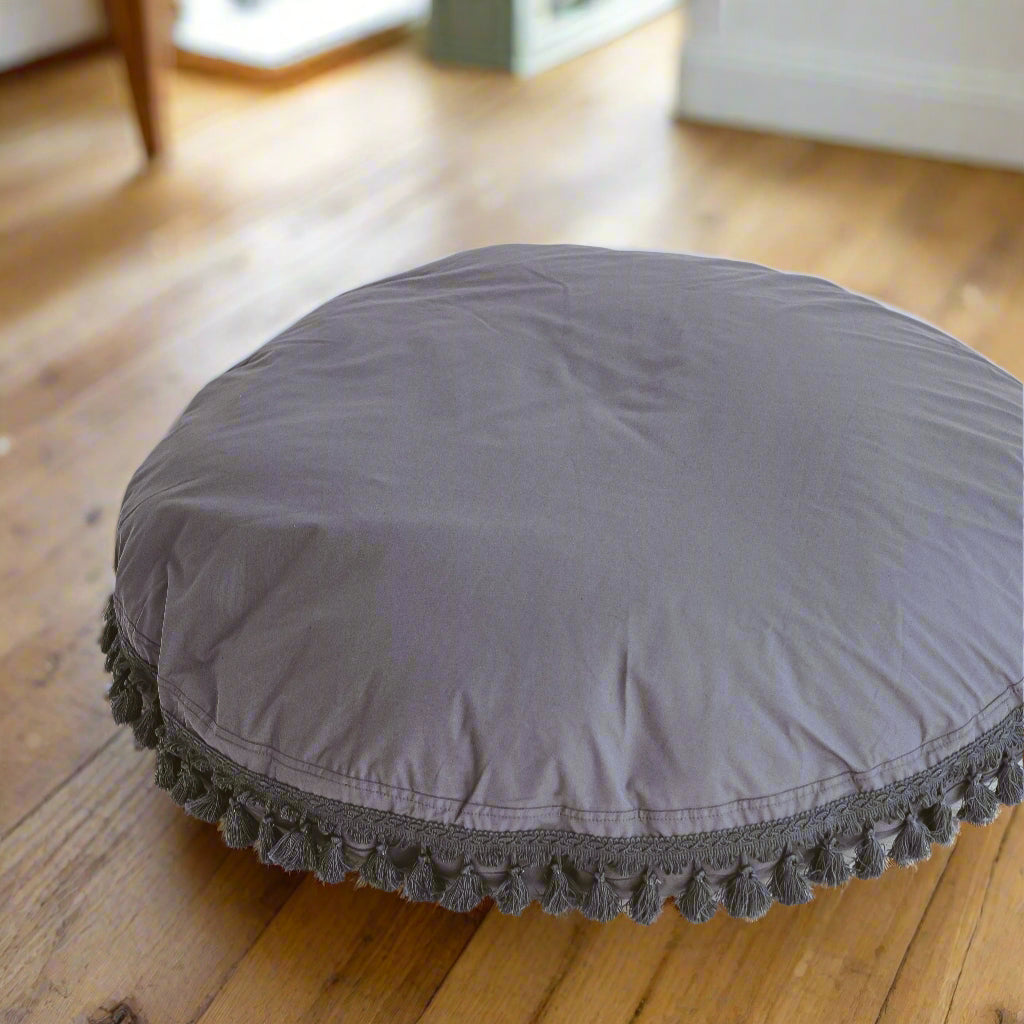 Large round floor cushion in a lovely blue/grey colour with a trim of darker grey with tassels around the edge