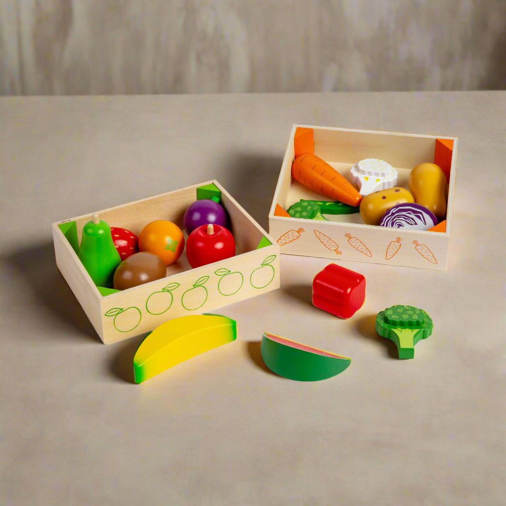 Wooden toy vegetables and fruits in two boxes on a white background