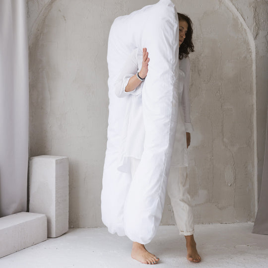 Person carrying the large U shaped pillow to show the full size of it