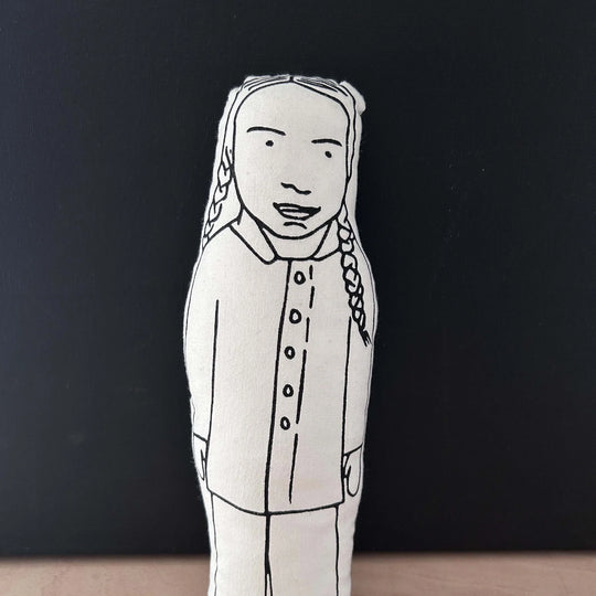 Screen printed doll cushion with white fabric and black illustration depicting a cartoon image of climate activist Great Thunberg